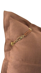 Détail du coussin artisanal MIYA en lin lourd moka glacé mettant en valeur la texture du tissu, la chaîne dorée et l’étiquette signature MIYA.