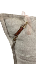 Détail coussin lin beige avec signature cuir MIYA et chaîne dorée – MIYA
