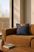 Coussin en lin bleu marine sur canapé en cuir dans un intérieur contemporain.