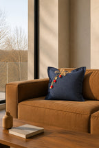 Coussin en lin bleu marine sur canapé en cuir dans un intérieur contemporain.