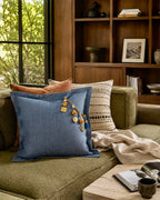 Coussin en lin lourd bleu ZANZIBAR No.100 avec pampille signature MIYA, sur canapé vert.