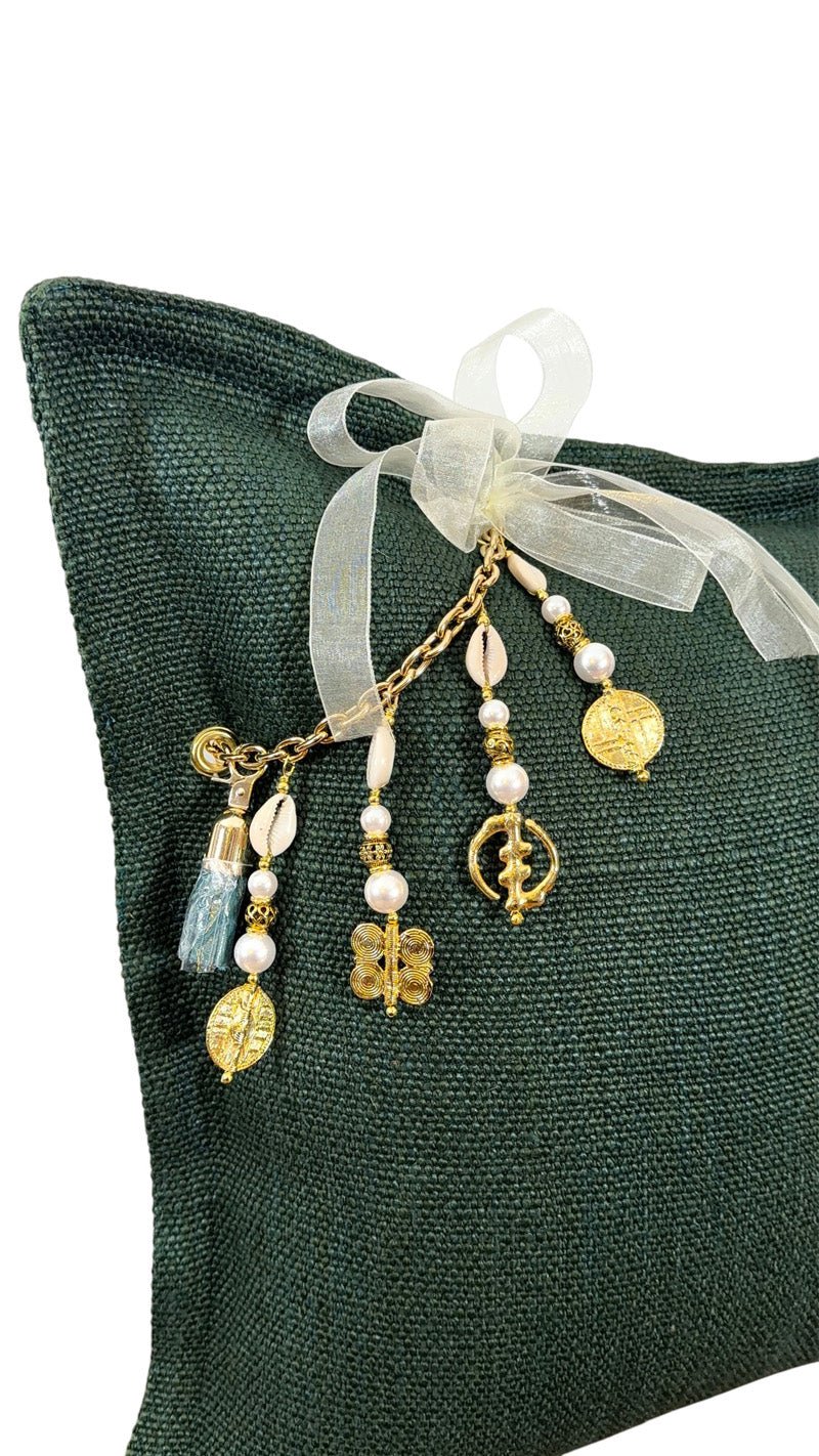 Détail de la pampille signature MIYA ornée de poids Ashanti et perles sur coussin vert émeraude, finition artisanale