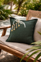 Coussin vert émeraude MIYA avec pampille signature MIYA ornée de poids Ashanti et perles, bohème chic sur fauteuil en bois