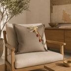 Coussin décoratif en lin lourd grège fait main sur fauteuil contemporain en chêne, avec pampille signature MIYA.