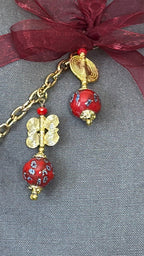 Detail of MIYA's signature tassel featuring red African beads and handcrafted brass Ashanti weights.