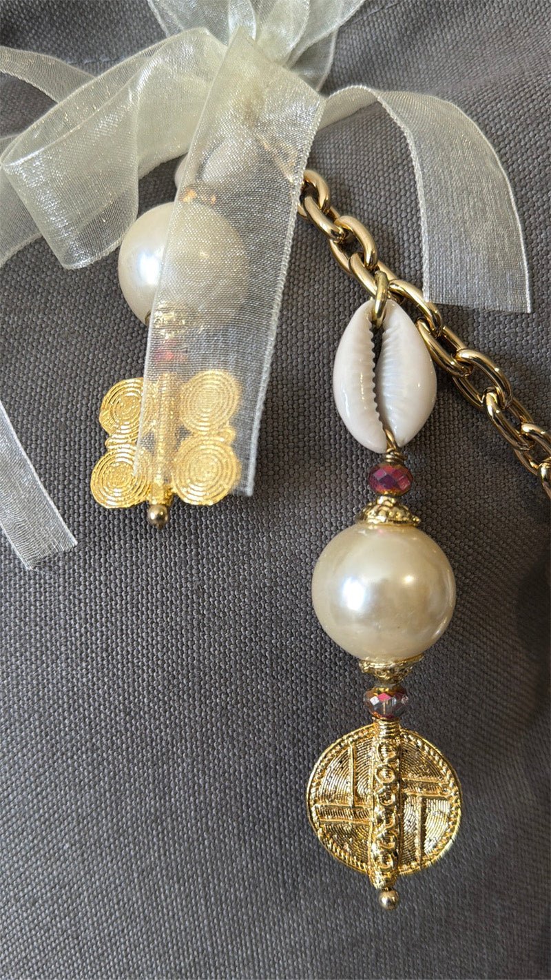 Détail de la signature MIYA avec perles nacrées, cauris et symboles Ashanti.