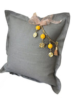 Vue de trois quarts du coussin en lin gris BALI No.68 avec pampille signature MIYA.