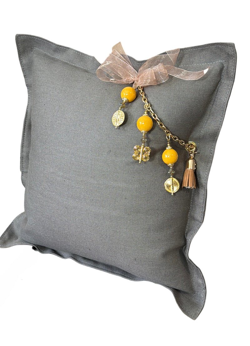 Vue de trois quarts du coussin en lin gris BALI No.68 avec pampille signature MIYA.