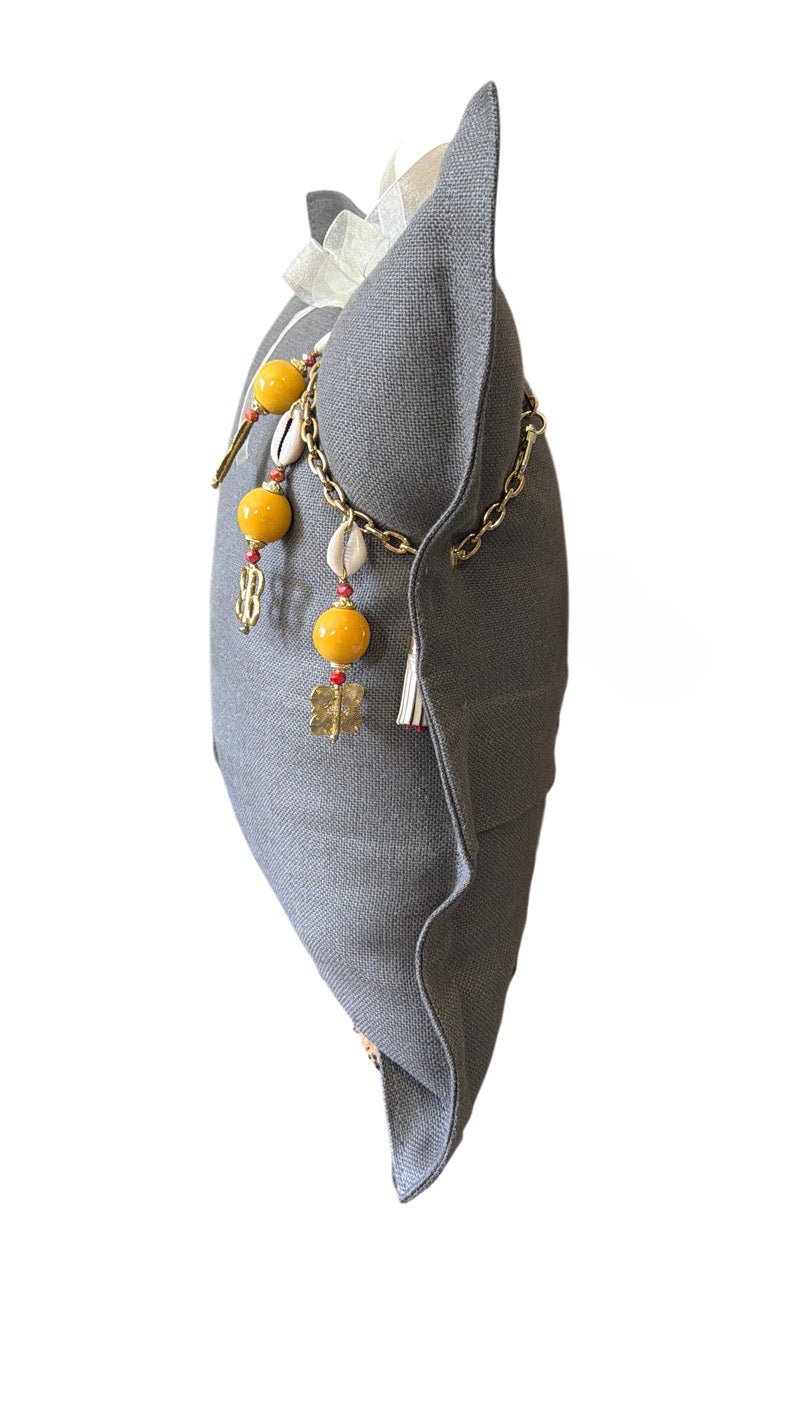 Vue de profil du coussin en lin gris BALI No.69 avec chaîne décorative et pampille signature MIYA.