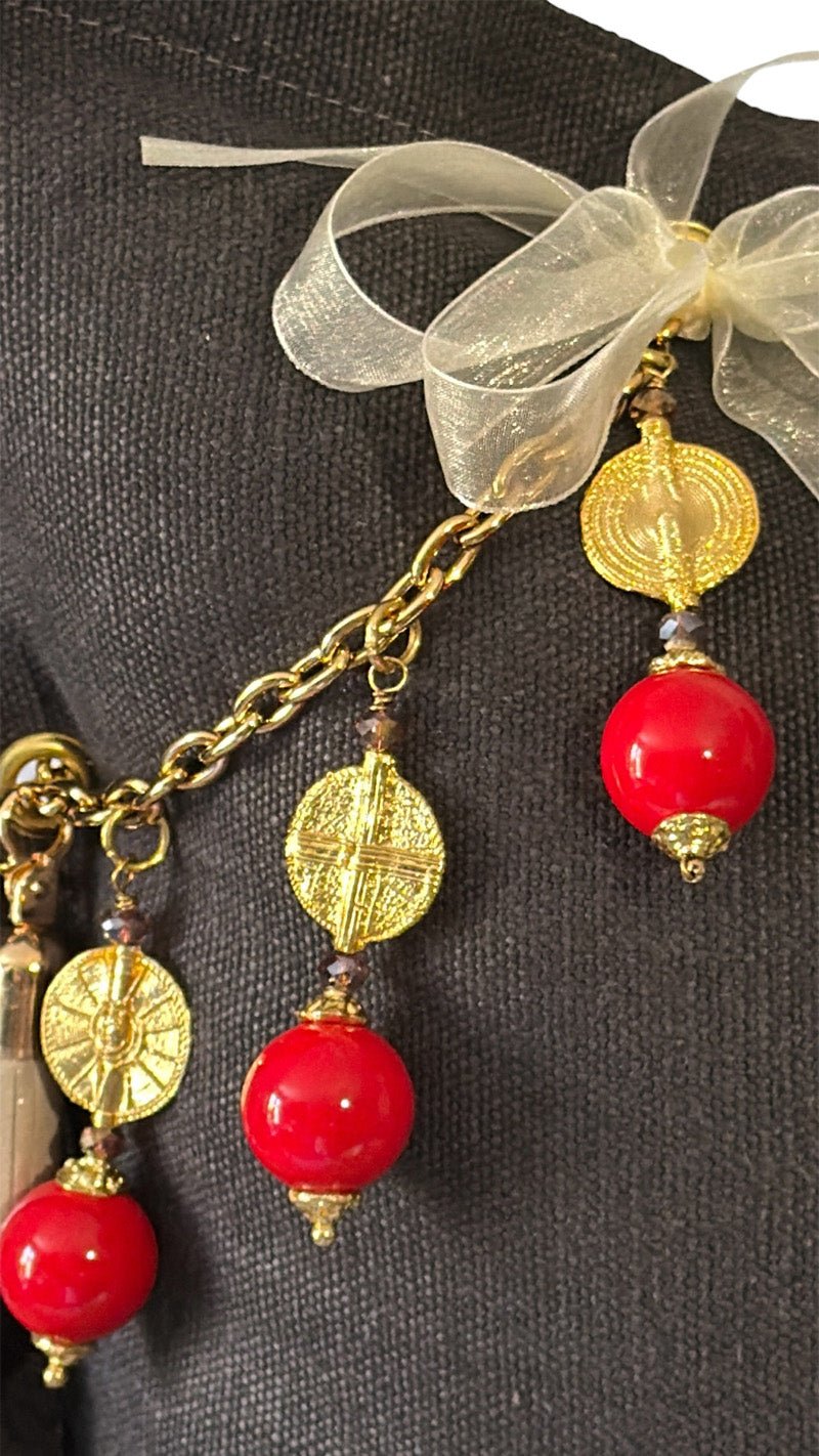 Zoom sur les grosses pampilles rouges et poids Ashanti . Coussin en lin MIYA