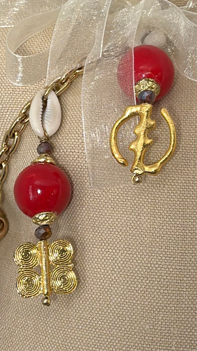 Détail de la pampille artisanale MIYA Zanzibar No.53 avec perles rouges, poids Ashanti traditionnels et ruban décoratif