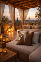 Coussin en lin brun posé sur une assise aux tons neutres, sur un rooftop à Marrakech