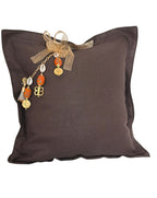 Coussin carré en lin lourd marron MIYA avec pampille signature, cauris et perles orange artisanales.