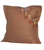 Coussin décoratif en lin lourd moka glacé MIYA avec pampille signature, perles africaines rouges et détails dorés pour intérieur bohème chic contemporain.