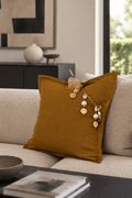 Coussin MIYA en lin moutarde sur canapé contemporain beige — pampille artisanale bohème chic.
