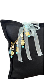 Détail coussin lin noir avec pampille signature ornée de poids Ashanti et perles – MIYA