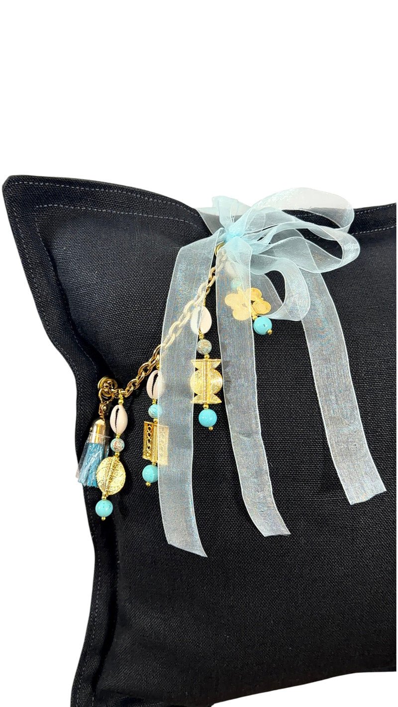 Détail coussin lin noir avec pampille signature ornée de poids Ashanti et perles – MIYA