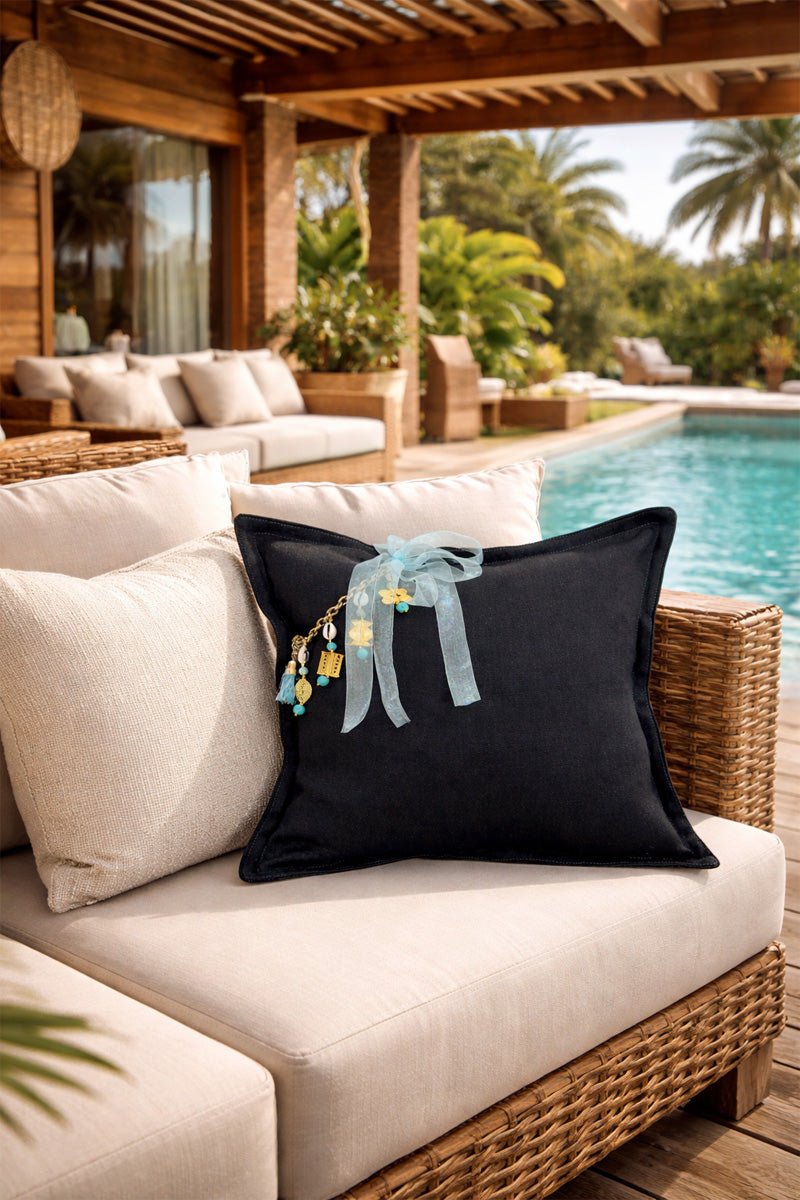 Coussin lin noir avec pampille signature ornée de poids Ashanti, ambiance resort tropical – MIYA