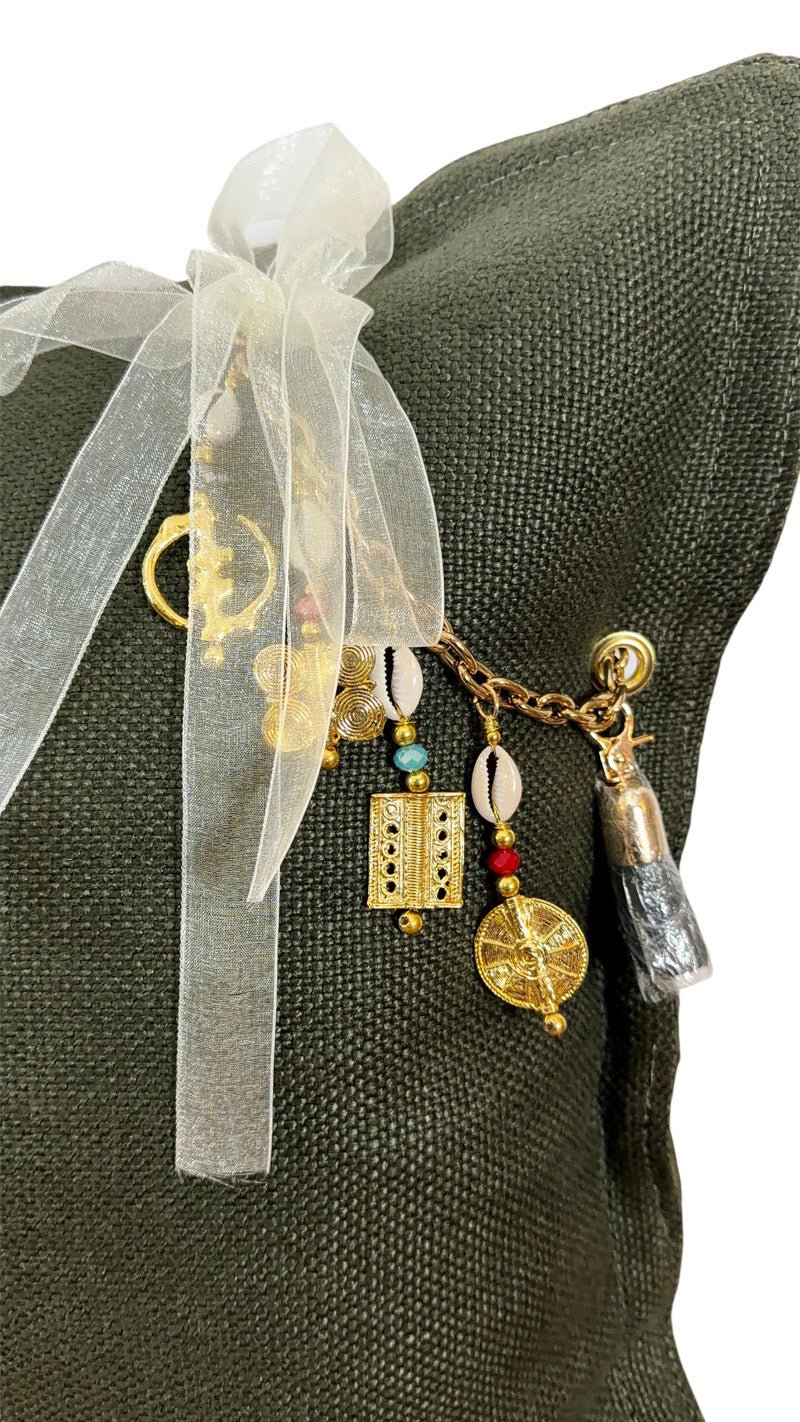 Détail coussin lin vert olive avec pampille signature ornée de poids Ashanti et perles – MIYA