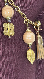 Détail de la pampille MIYA avec perles beige rosé, poids Ashanti dorés et pampille cuir ton sable