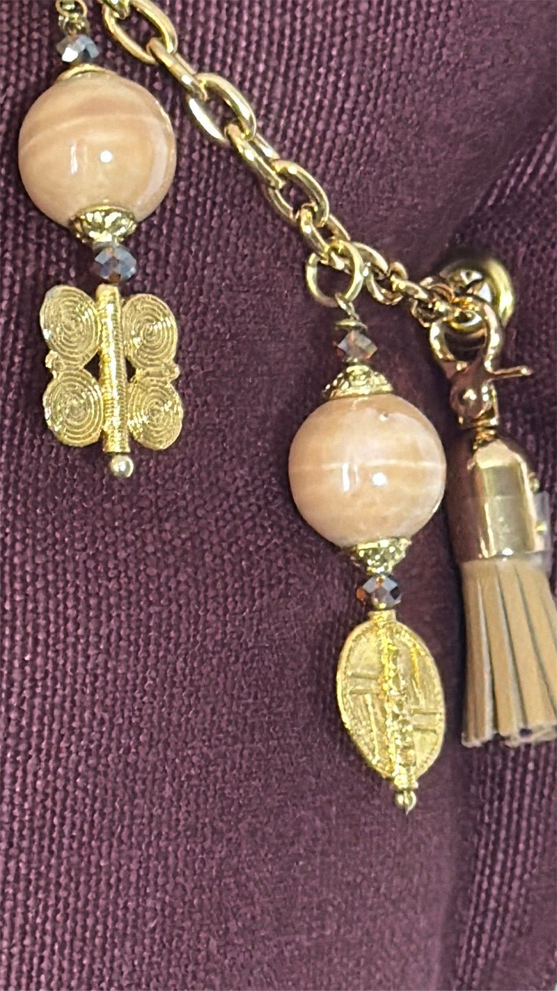 Détail de la pampille MIYA avec perles beige rosé, poids Ashanti dorés et pampille cuir ton sable