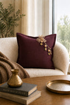 Coussin en lin lourd prune MIYA avec pampille signature Ashanti dans un intérieur bohème chic contemporain.