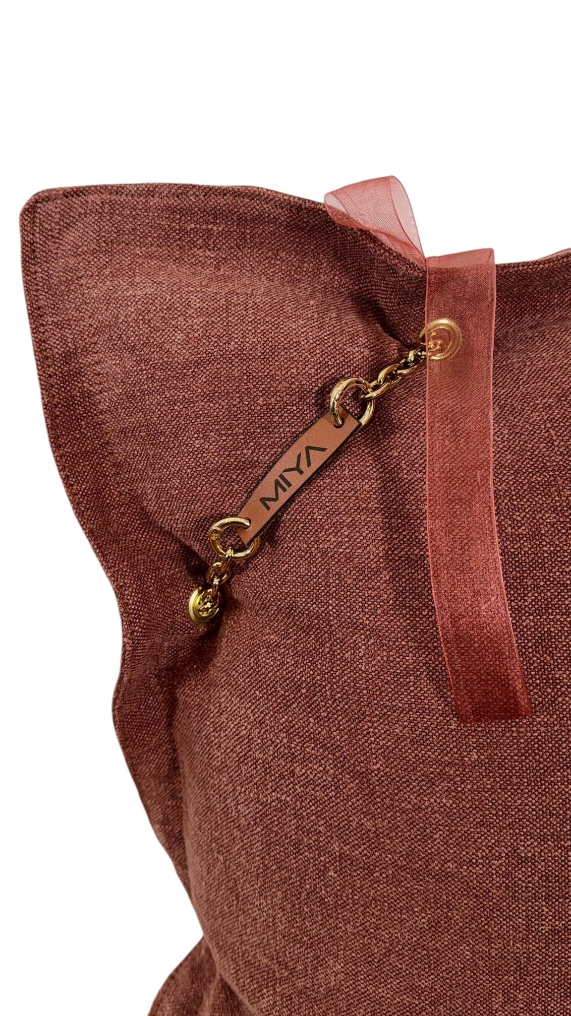 Détail arrière avec étiquette signature MIYA sur coussin rose sienne.