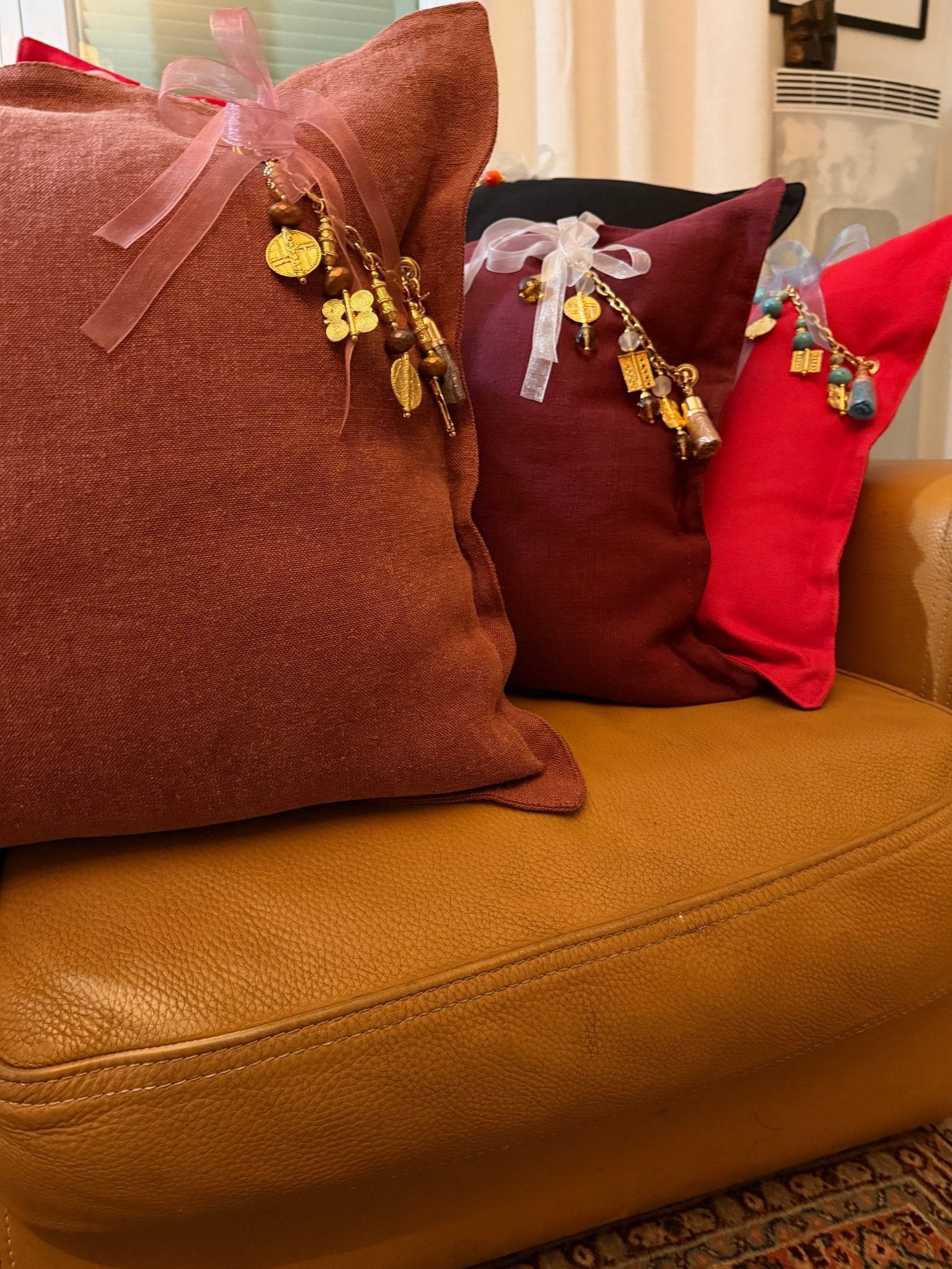 Coussin en lin rouille SIERRA by MIYA posé dans un intérieur bohème chic, ambiance douce et intime