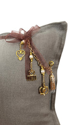 Détail dos coussin en lin taupe MIYA avec attache en cuir signature et finitions dorées artisanales