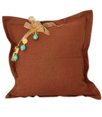 Coussin décoratif en lin lourd terracotta MIYA avec pampille signature et perles vert d’eau pour intérieur bohème chic contemporain.