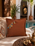 Coussin décoratif MIYA MARRAKECH No.49 en lin lourd terracotta mis en scène dans un riad marocain contemporain, posé sur une banquette écrue au bord d’un bassin.