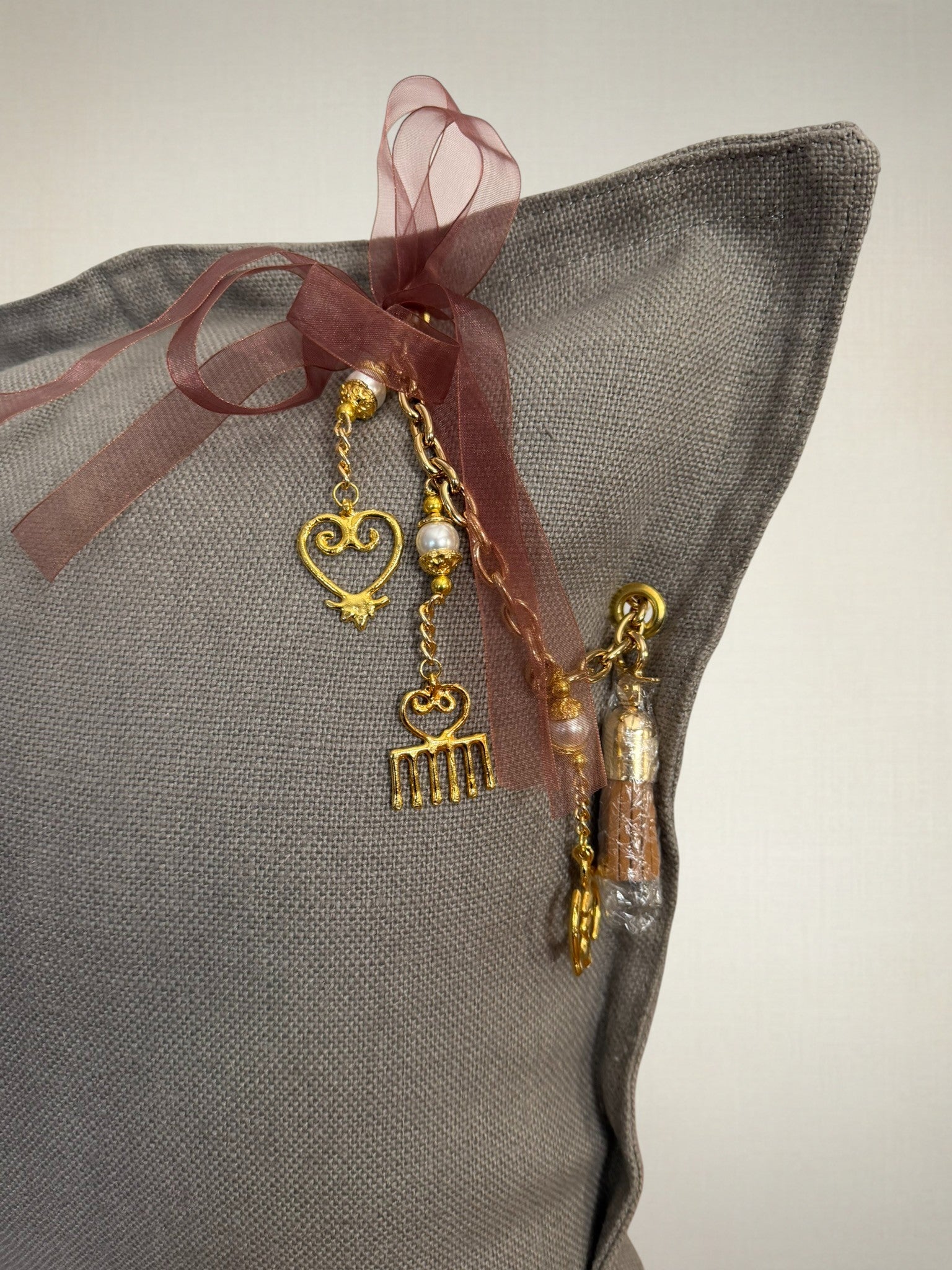 Coussin décoratif en lin gris SIERRA by MIYA, teinte gris subtil et matière naturelle, détail de pampille raffinée.