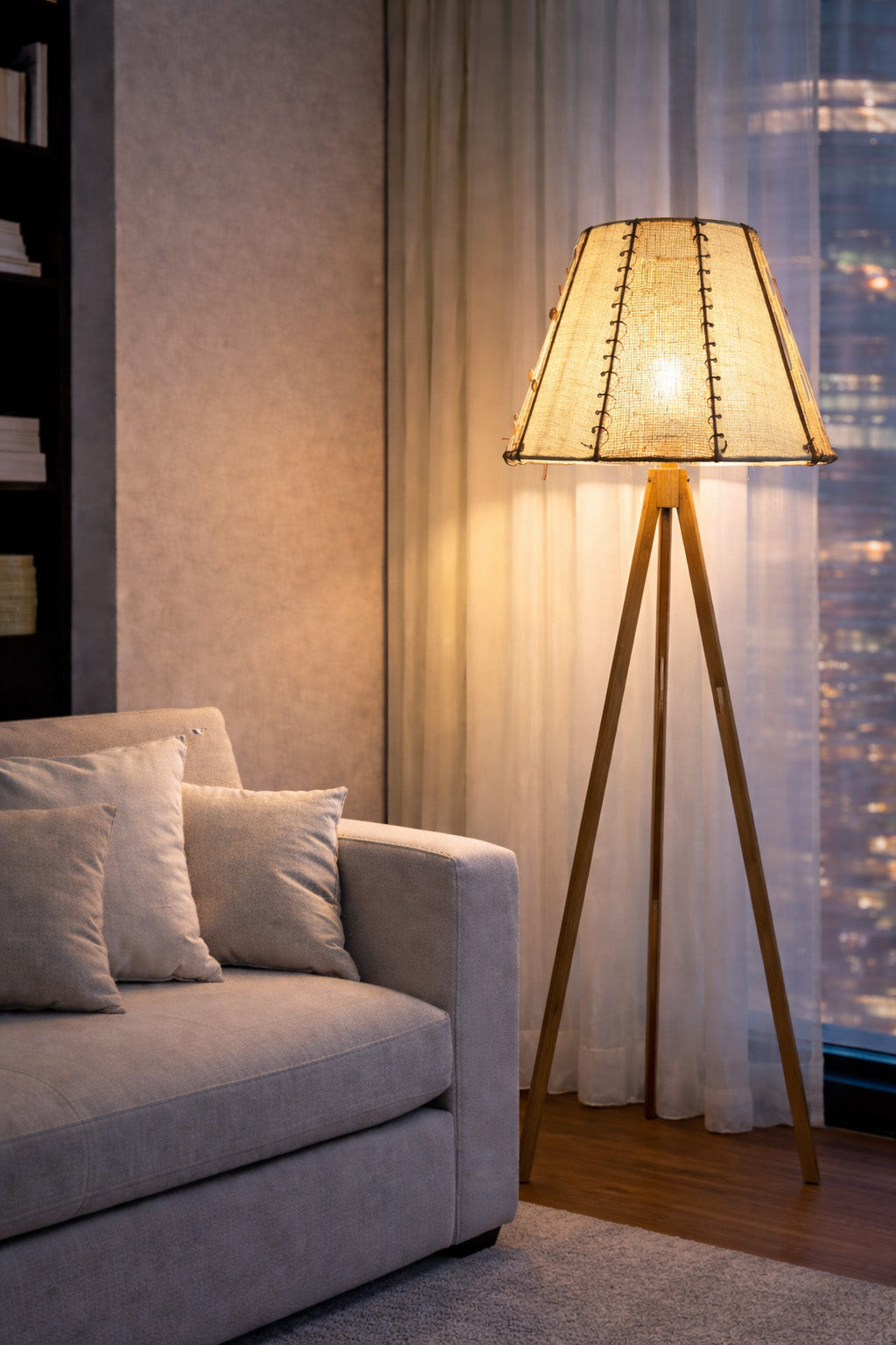 lampadaire MIYA allumé dans un séjour moderne devant une baie vitrée