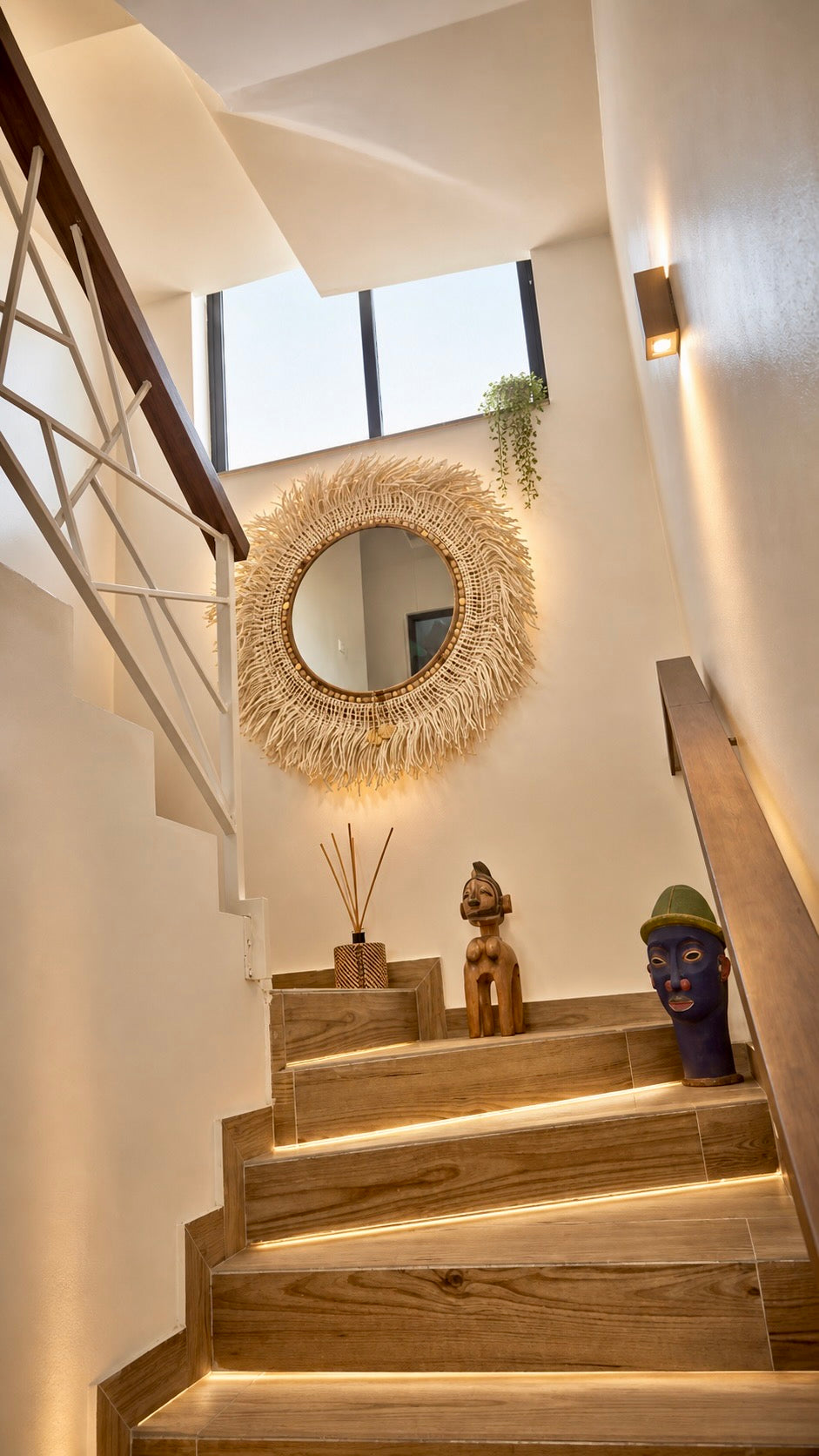 Miroir artisanal OPHELIE MIYA installé dans un grand escalier, pièce décorative en fibres naturelles fabriquée en France.