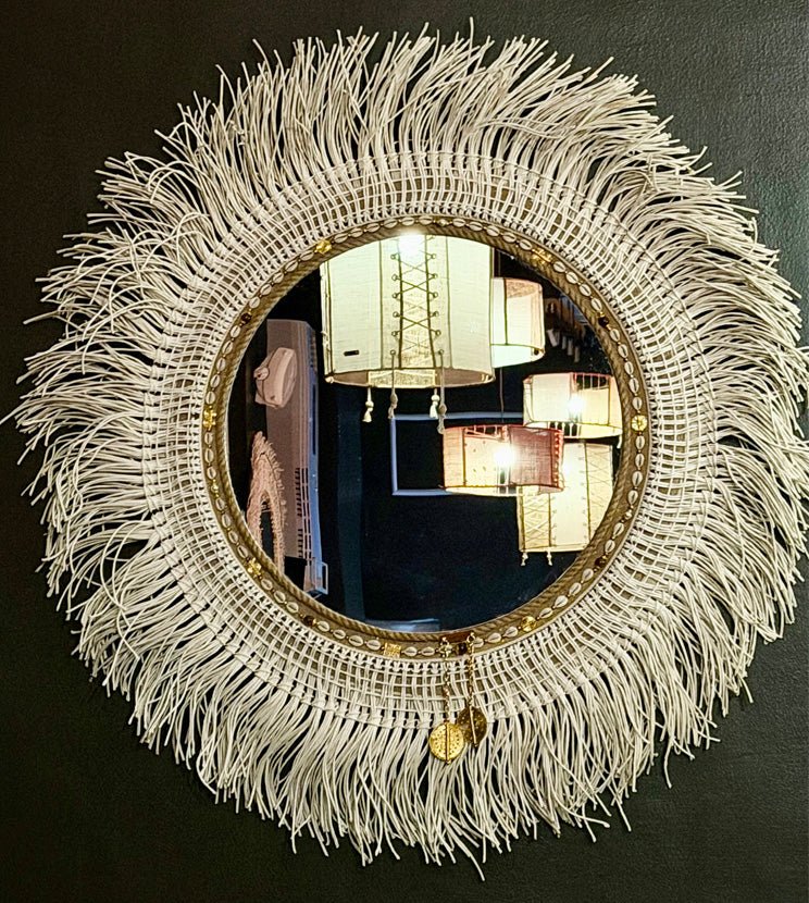 Miroir artisanal en fibres tressées avec franges et détails dorés, style bohème chic sur fond sombre – MIYA
