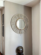 Miroir en fibres tressées avec finitions naturelles, coquillages et poids Ashanti, installé dans un angle lumineux – MIYA