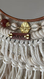Détail des cauris, perles, poids Ashanti et signature MIYA en cuir.